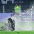 Football or swimming? Santos star washes his face in a puddle during bizarre Brazilian match